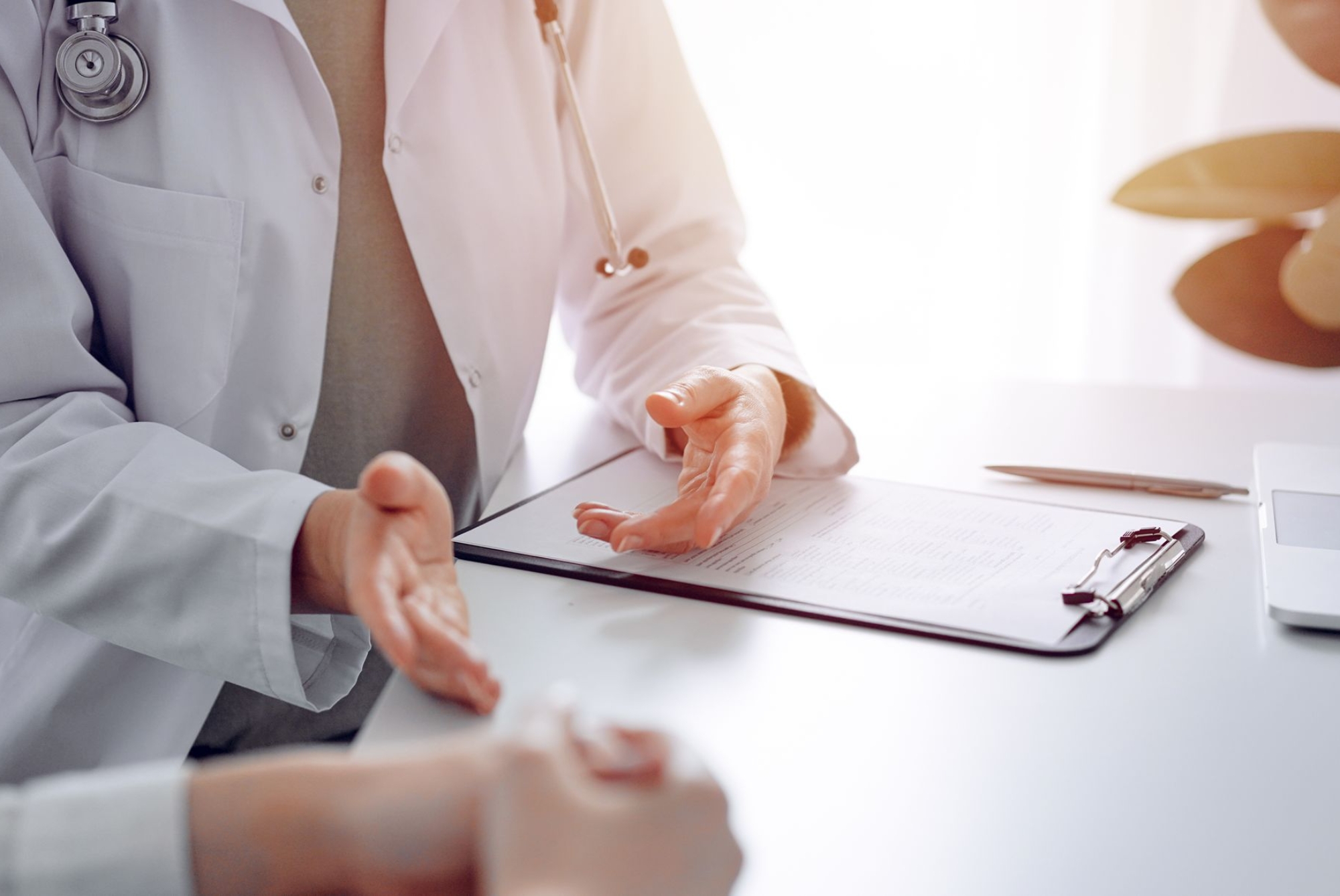m_doctor-patient-discussing-current-health-examination-while-sitting-desk-clinic-office-closeup-perfect-medical-service-medicine-concept